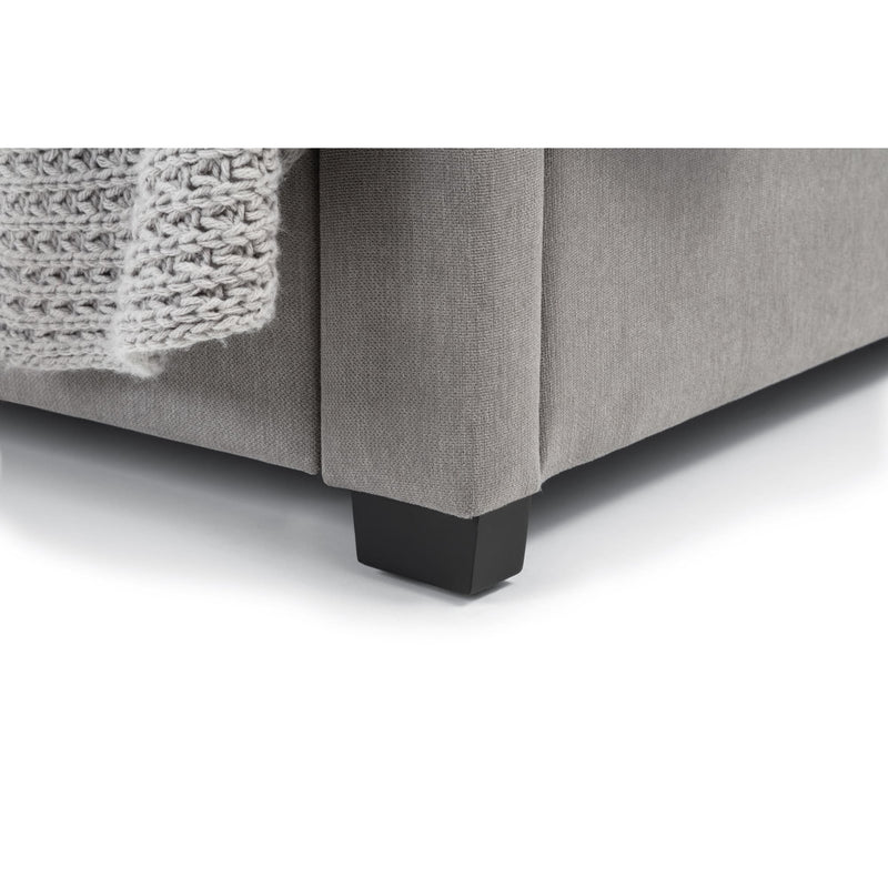 Gray upholstered bed with dark wooden feet on a white background