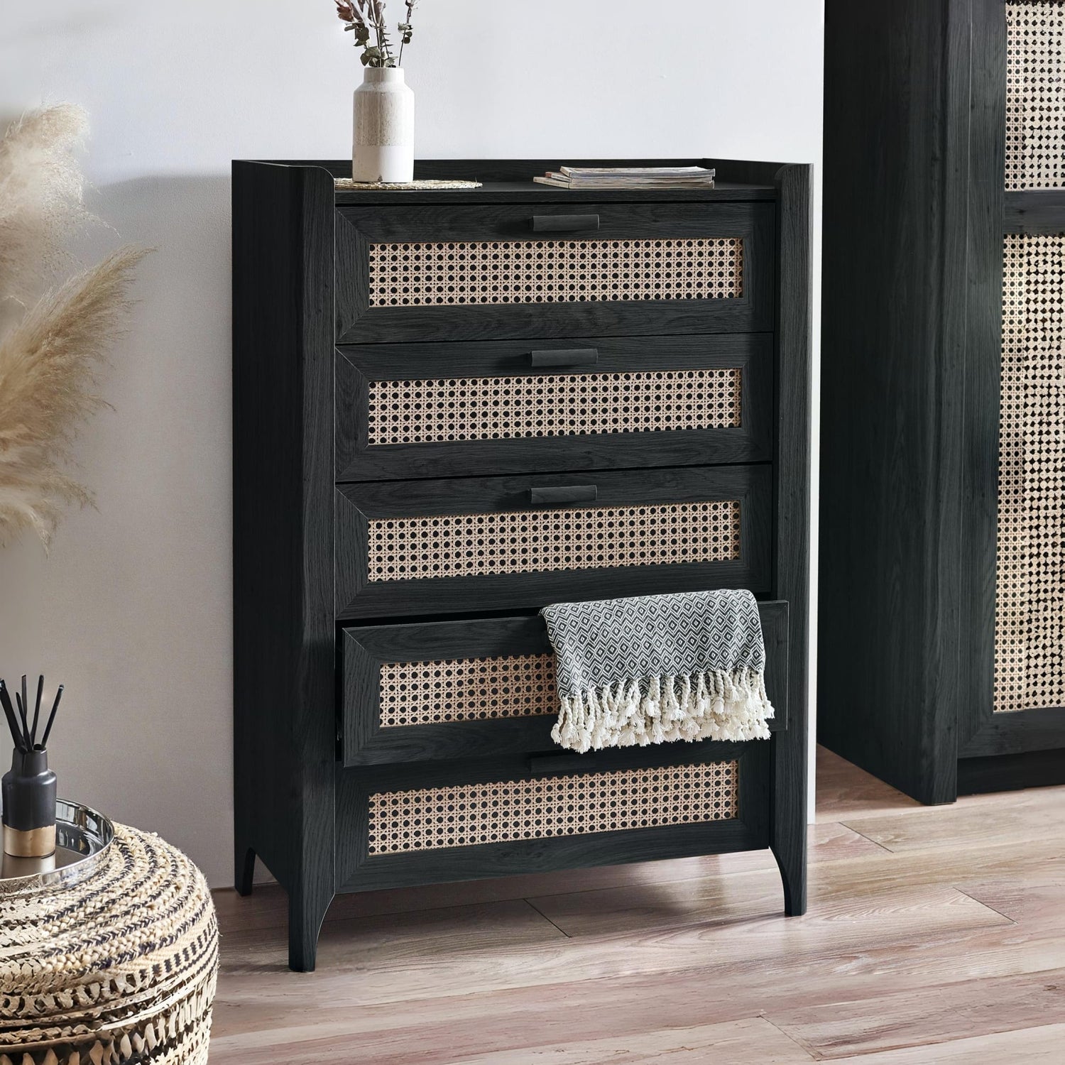 Black dresser with wicker drawers in a room setting
