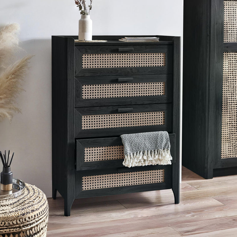 Black dresser with wicker drawers in a room setting