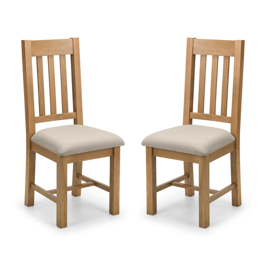 Two wooden chairs with beige cushioned seats on a white background