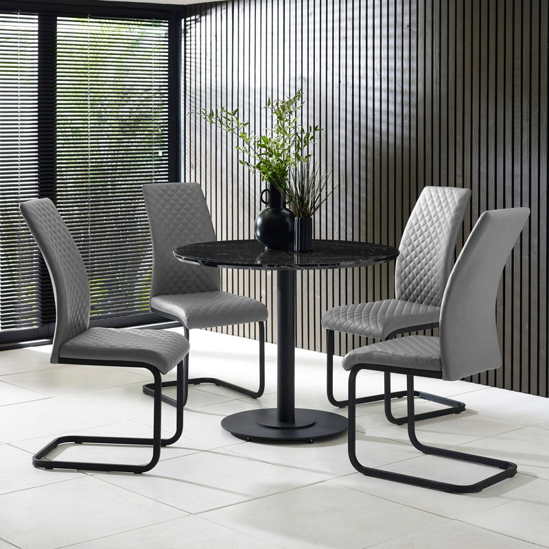 Dining set with four gray chairs and a black round table in a modern interior setting.