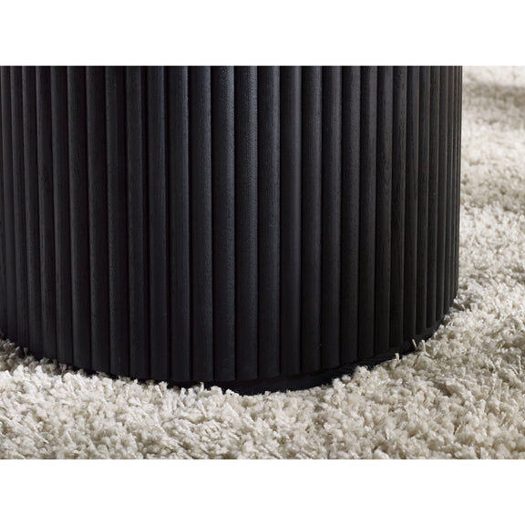 Black ribbed cylindrical object on a white carpet