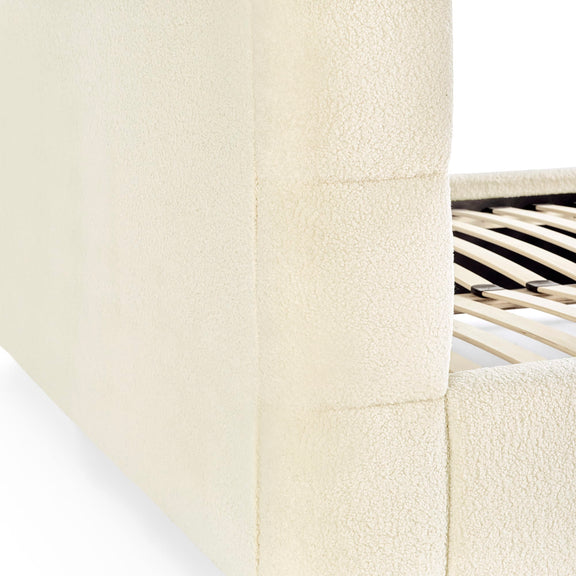 Close-up of a textured white surface with a metallic chair leg in the corner.