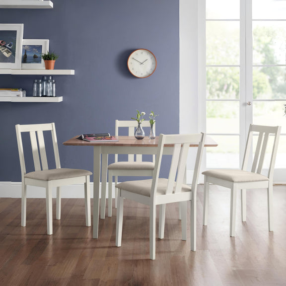 Dining room with a wooden table and white chairs against a blue wall.