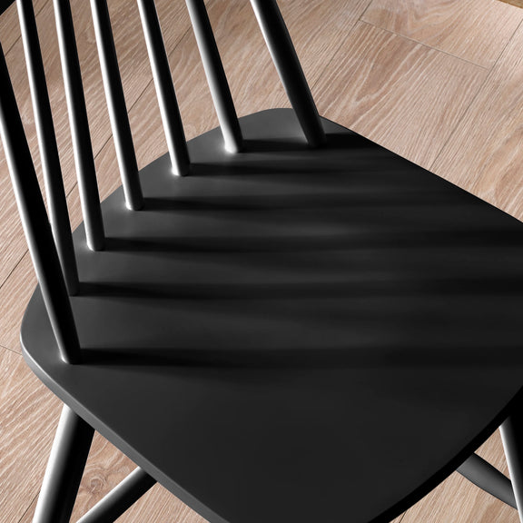 Black chairs stacked on a wooden floor