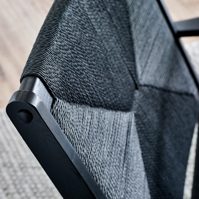 Close-up of a chair with gray mesh backrest and black frame.