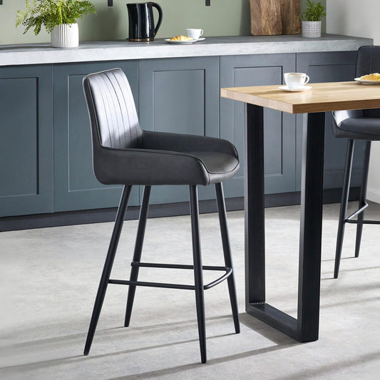 Modern kitchen with gray bar stools and a wooden table.