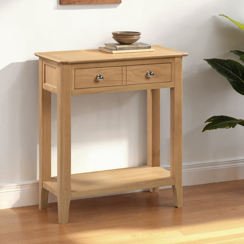 Wooden console table with two drawers and a shelf in a room setting.