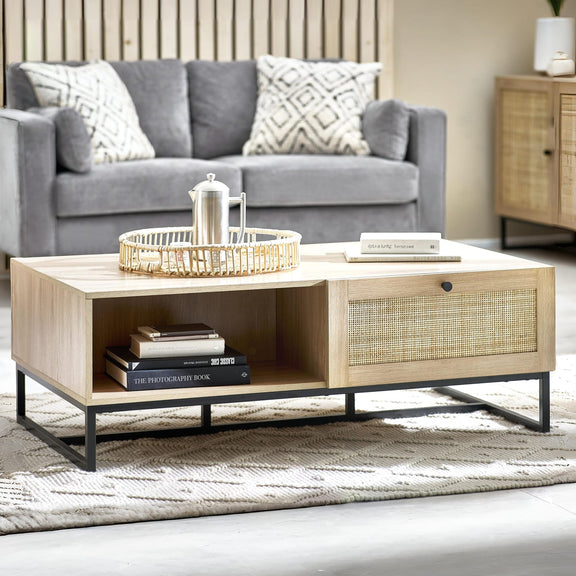 Wooden coffee table with books and a basket in a living room setting.