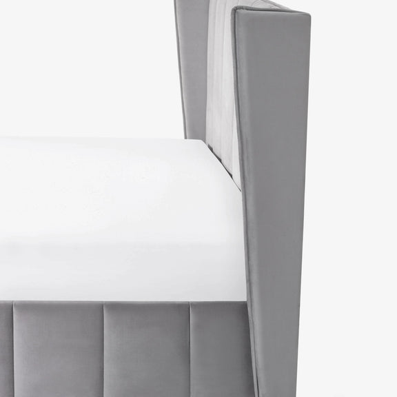Gray upholstered chair with a white cushion on a white background