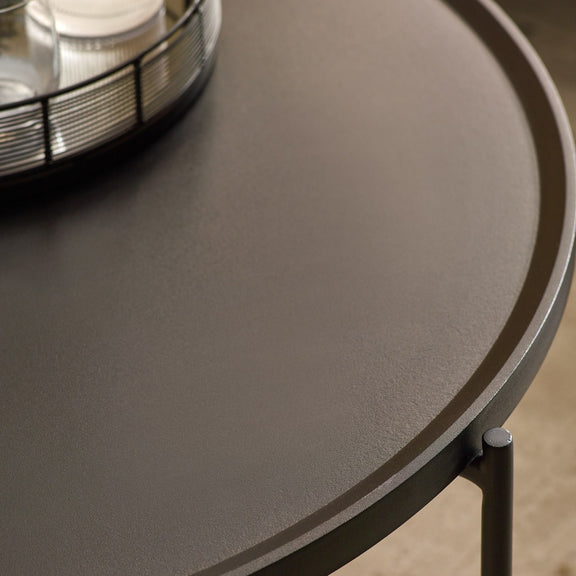 Round dark gray table with a metallic object on top