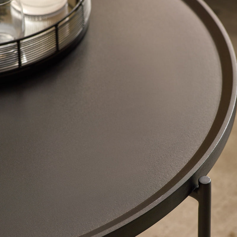 Round dark gray table with a metallic object on top