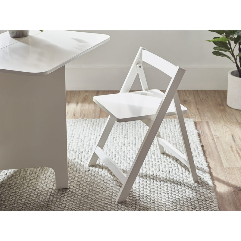 White folding chair next to a white table on a wooden floor with a rug