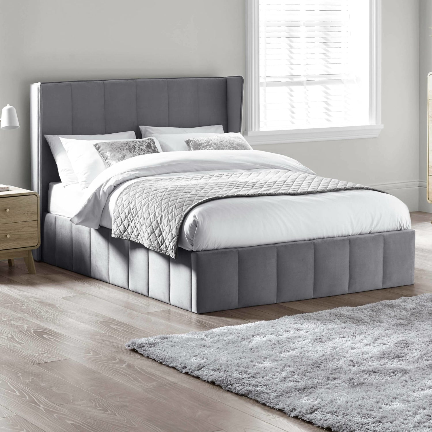 Gray upholstered bed with white bedding in a bedroom setting
