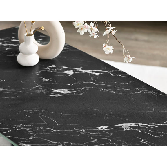 Black marble countertop with white flowers and decorative items