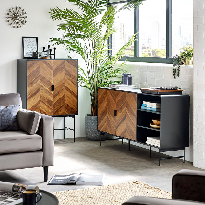 Modern living room with wooden and black furniture, plants, and a gray sofa.