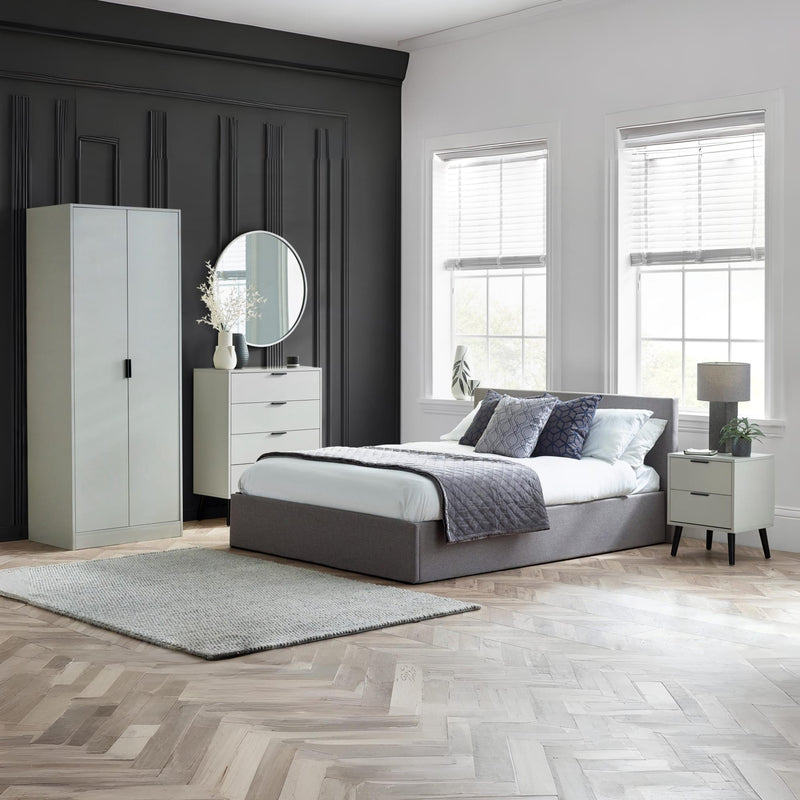 Modern bedroom with gray bed, white dresser, and large windows.