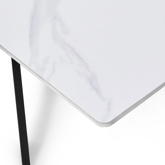 White tablecloth on a white table with a black leg