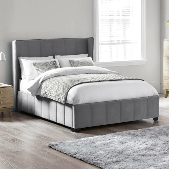 Gray upholstered bed with white bedding in a bedroom setting