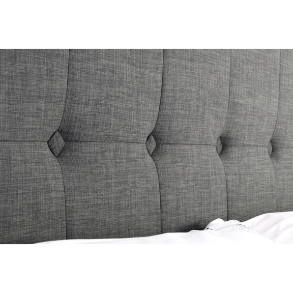 Gray tufted headboard with button details on a white background