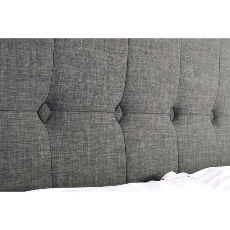 Gray tufted headboard with button details on a white background