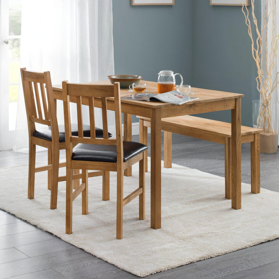 Wooden dining set with table, chairs, and bench in a room with gray walls and white curtains.