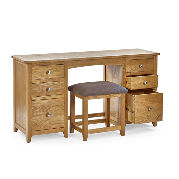 Wooden desk with multiple drawers and a stool on a white background