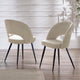 Two beige chairs with black legs on a wooden floor.