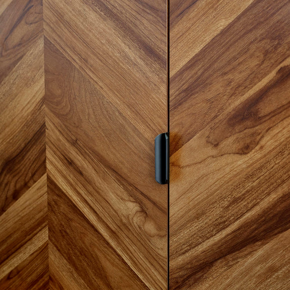 Close-up of a wooden cabinet with a black handle
