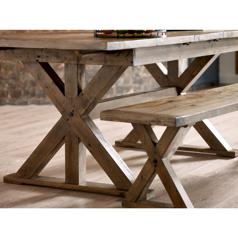 Wooden dining table with X-shaped legs and matching bench on a wooden floor.