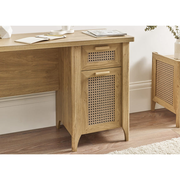 Wooden desk with a rattan-patterned drawer in a room setting.