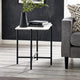 Small side table with books and a vase next to a gray sofa in a living room.