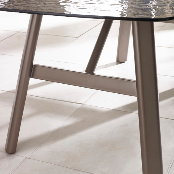 Close-up of a table with a marble-like top and metal legs on a light tiled floor.