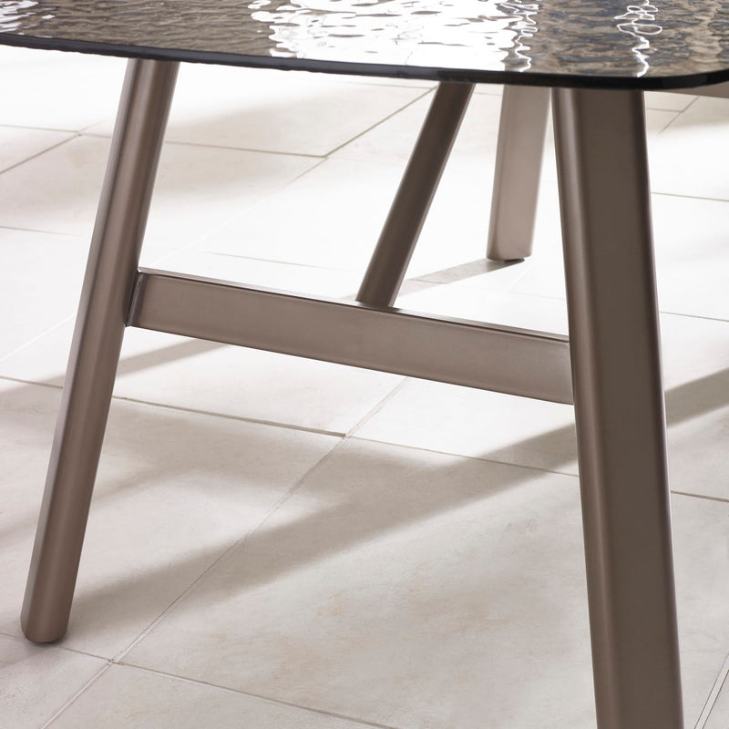 Close-up of a table with a marble-like top and metal legs on a light tiled floor.