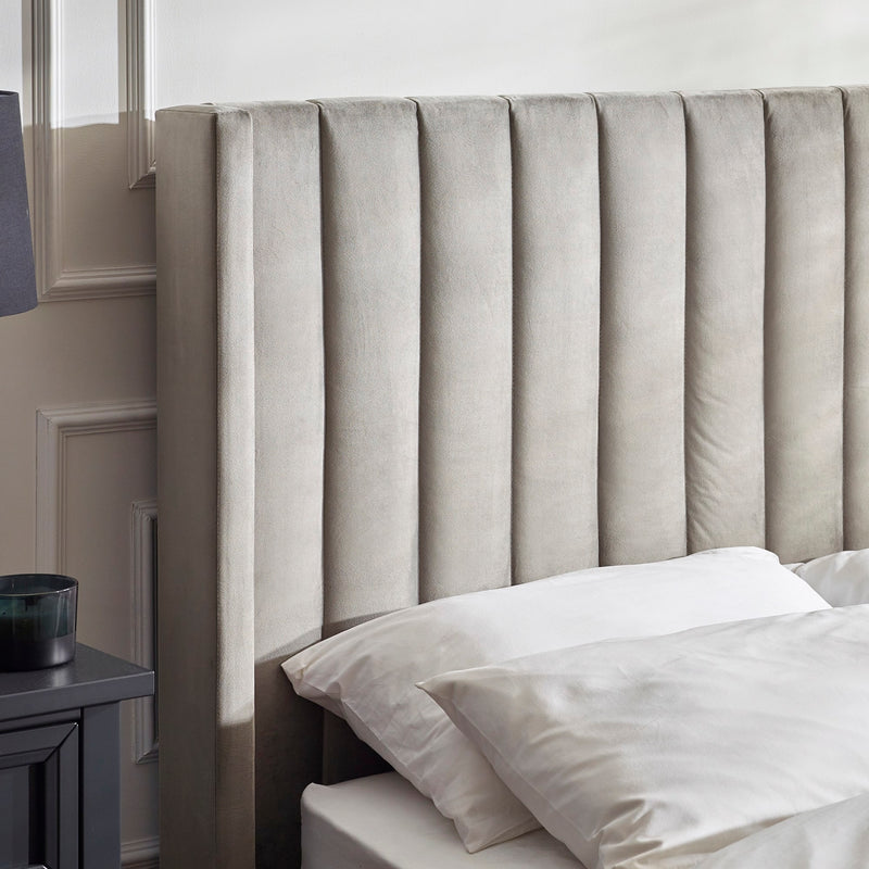 Gray upholstered headboard with white bedding in a bedroom setting