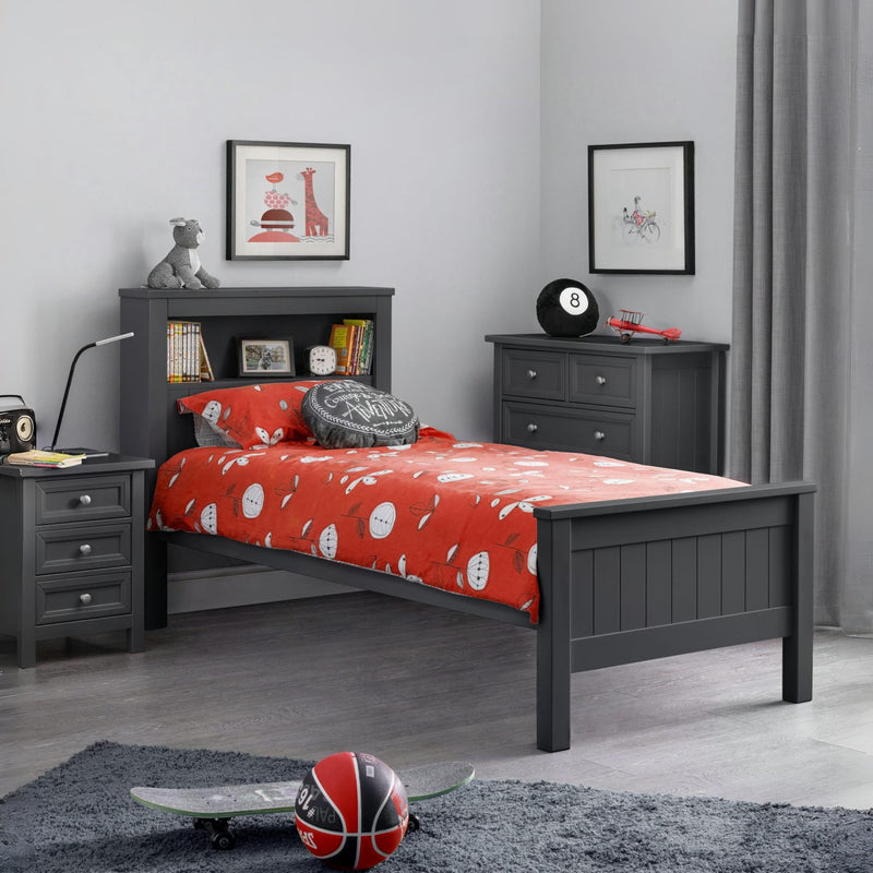Children's bedroom with gray bed frame, red bedding, and sports-themed decor.