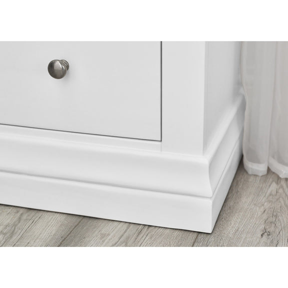 White cabinet with a silver knob on a wooden floor