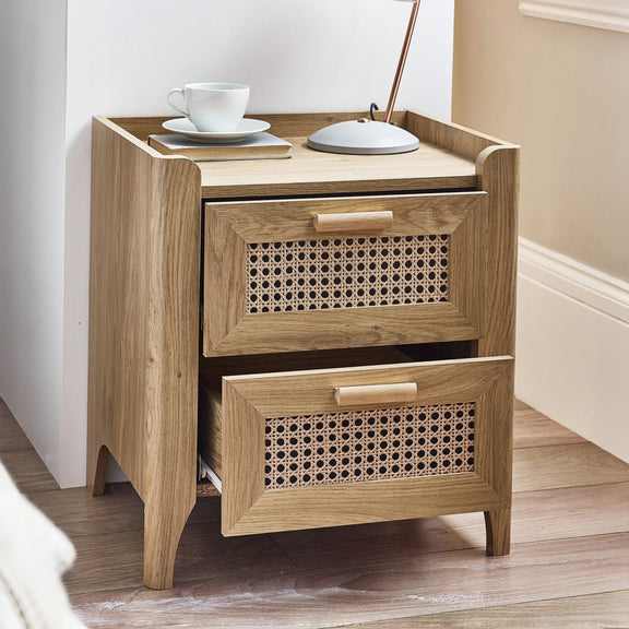 Modern oak bedside cabinet with woven rattan drawers in bedroom