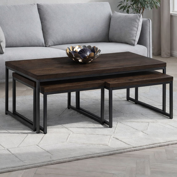 Set of wooden coffee tables with a decorative bowl on top in a living room setting.