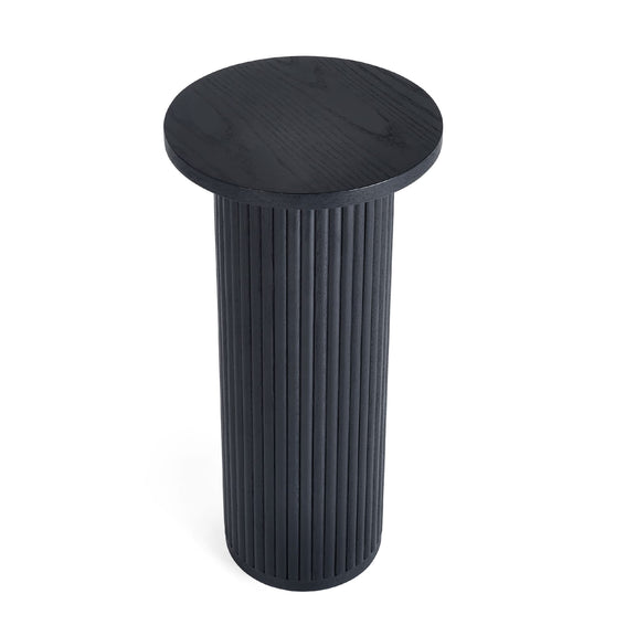 Black cylindrical side table with ribbed design on a white background