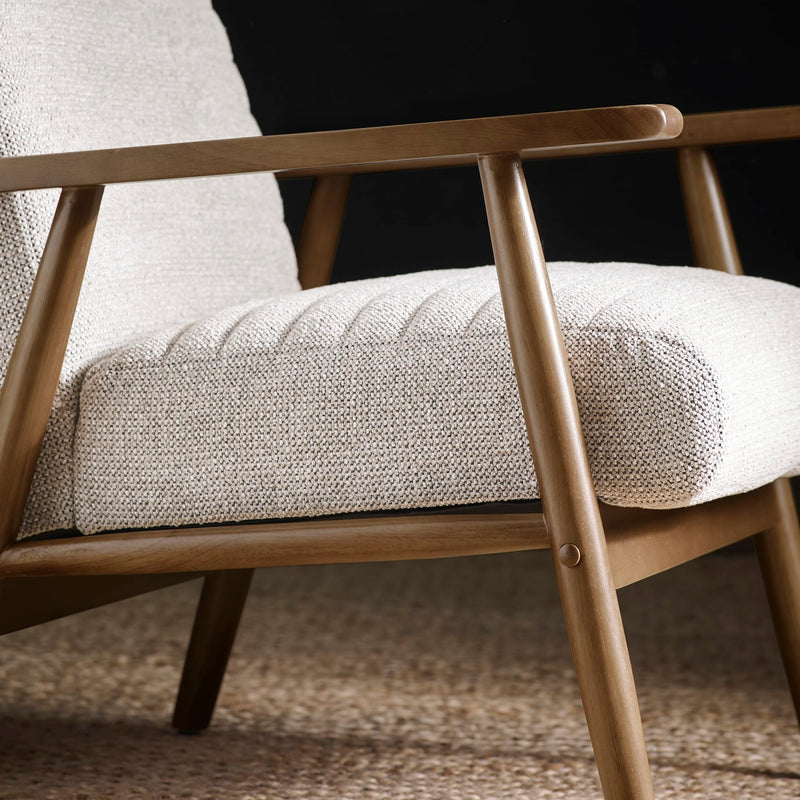 Close-up of a wooden armchair with beige cushioned seat and backrest.