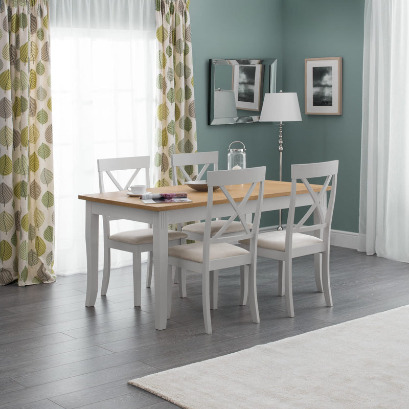 Dining room with a wooden table and white chairs against a light blue wall.