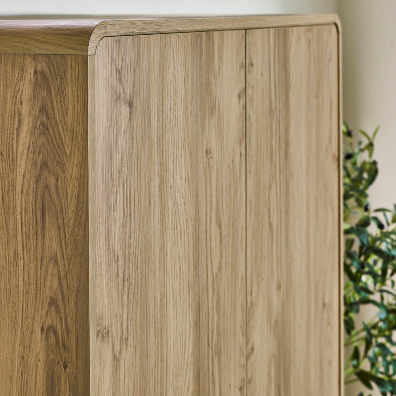 Close-up of a wooden cabinet with a plant in the background