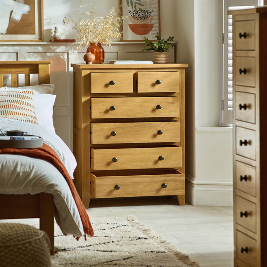 Wooden dresser in a bedroom with a bed and decor