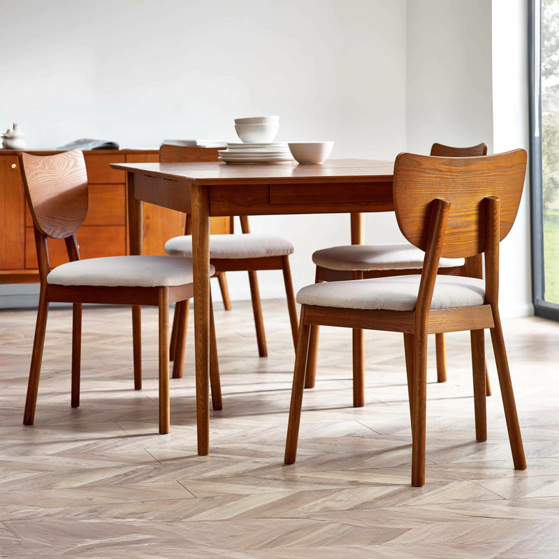 Wooden dining table with chairs in a bright room