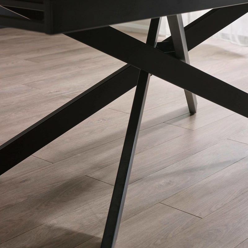 Close-up of a black metal chair leg on a wooden floor