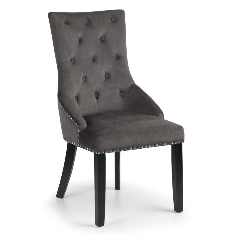 Gray upholstered chair with button tufting and wooden legs on a white background