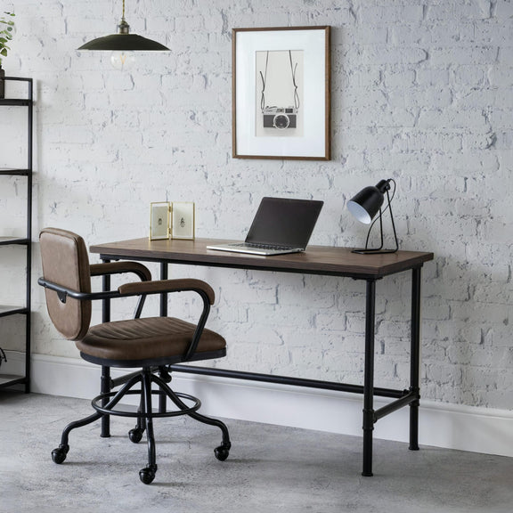 Modern office desk with chair against a white brick wall.