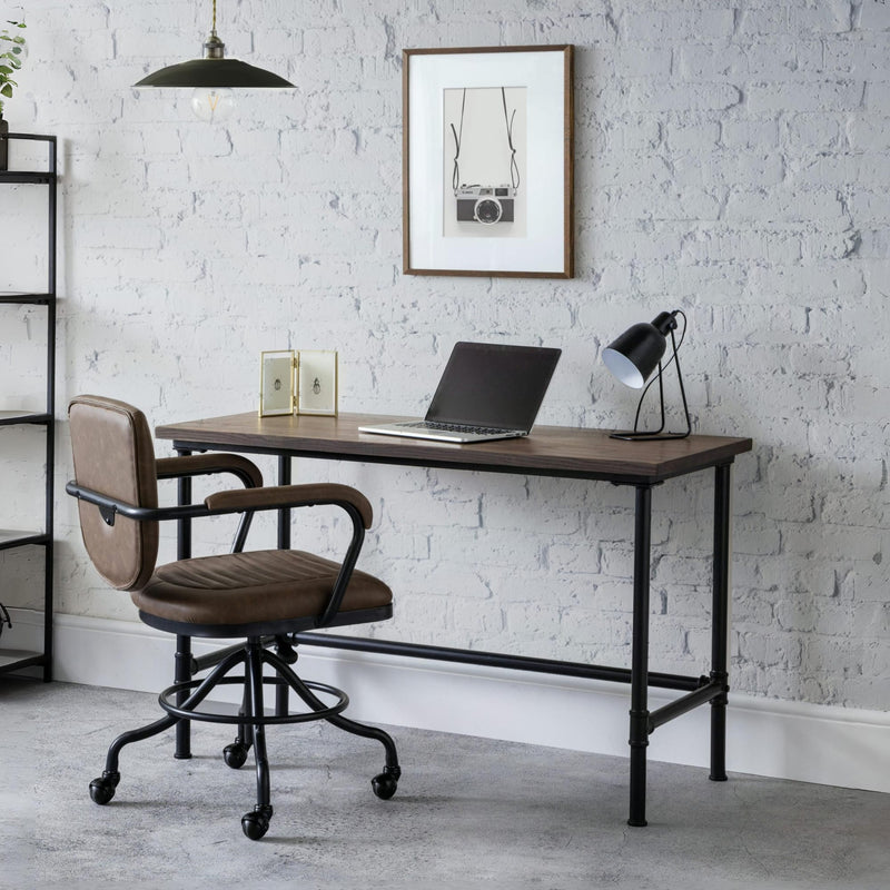 Modern office desk with chair against a white brick wall.