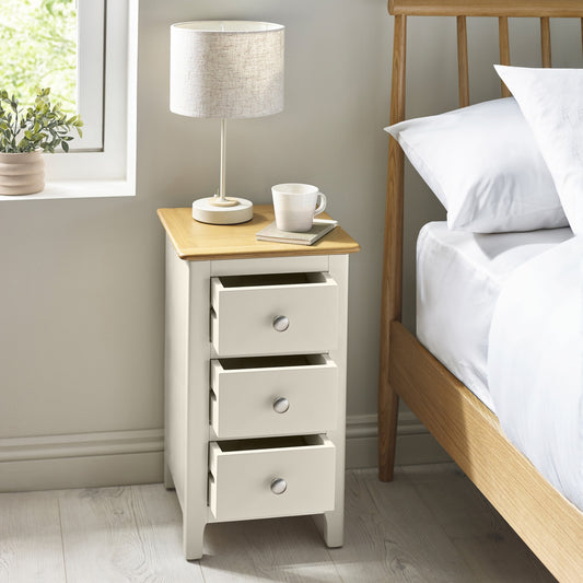 Compact white 3 drawer bedside cabinet with oak effect top in bedroom
